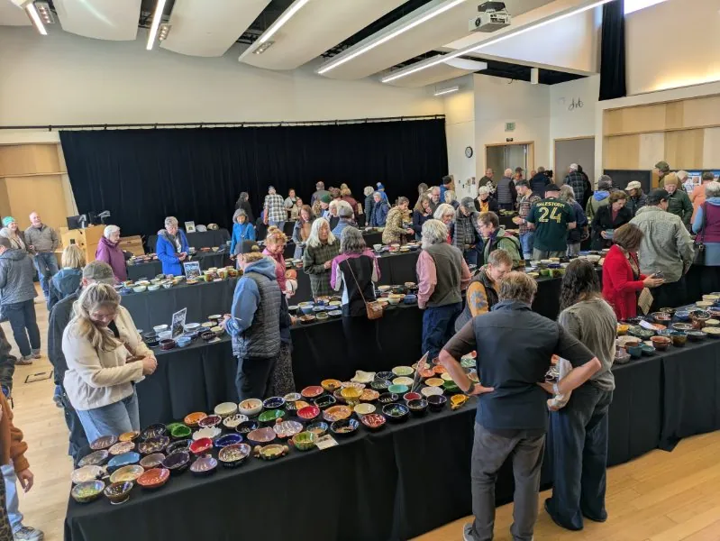 A room full of tables covered in handmade ceramic bowls